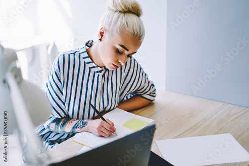 Young woman making transaction money online on tablet sitting in office