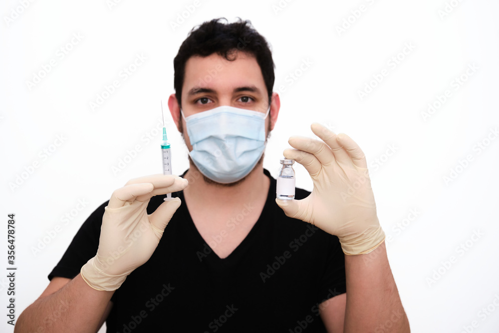 Male nurse with a syringe and vaccine vial in his hands Male nurse with a syringe and vaccine vial in his hands