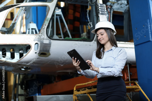 Wallpaper Mural Portrait of a solid businesswoman holding tablet , controlling work process in a airplane manufactory. Office worker. Torontodigital.ca