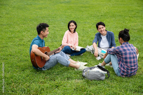 Happiness of college students play the guitar singing on the grass photo