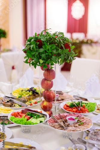Red apples and flowers in vase. Wedding decoration.