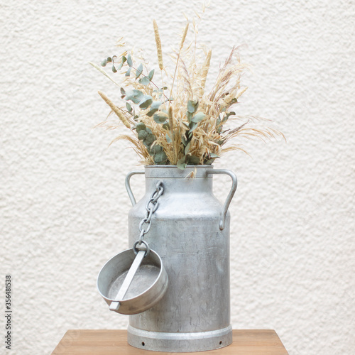 Pot à lait décoré avec des fleurs séchées photo