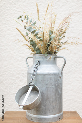 Pot à lait décoré avec des fleurs séchées photo