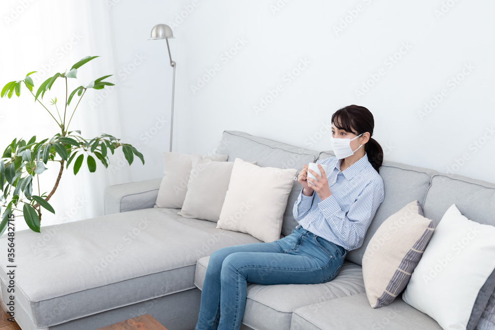 マスクをしてお茶を飲んでいる女性 マスクをしてお茶を飲んでいる女性