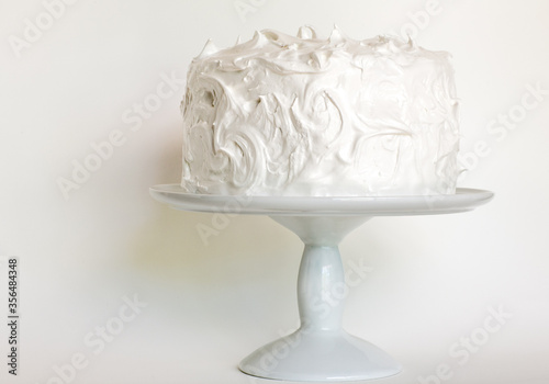 frosted white cake on stand