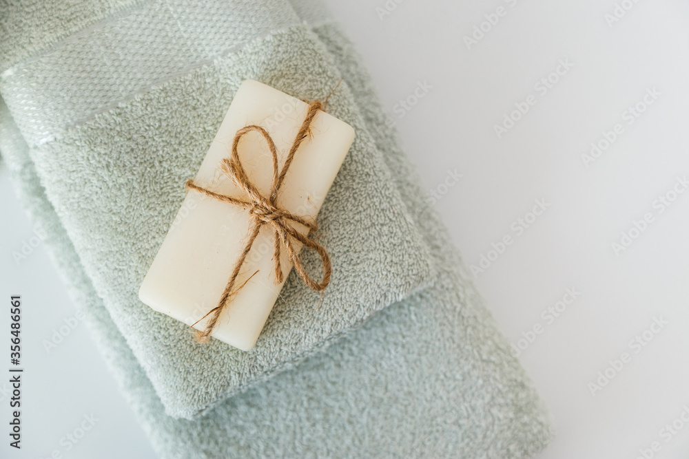 Solid soap corded on bath towels on white background with copy space. Top view with copy space Solid soap corded on bath towels on white background with copy space. Top view with copy space
