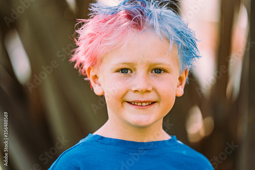 Young boy with colored hair smiling at camera