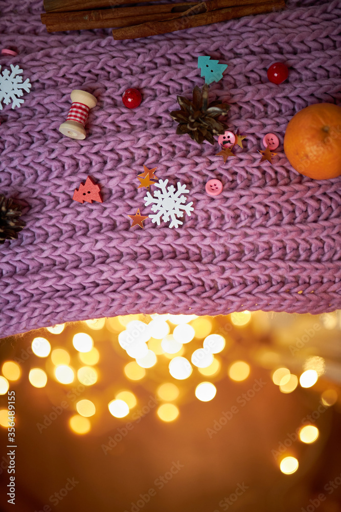 Photo for the New Year card. New Year's composition. View from above. Warm knitted scarf in purple. Tangerines lie on a scarf. Christmas composition with tangerines and a scarf.2021