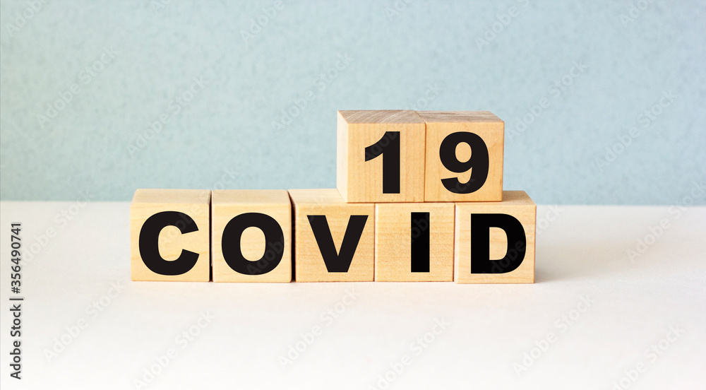 Text covid 19 on wooden blocks and a light background. Medicine concept Text covid 19 on wooden blocks and a light background. Medicine concept