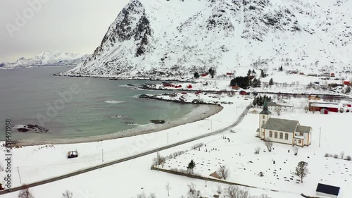 4k drone forward video (Ultra High Definition) of Valberg village, Norway, Europe. Snowy winter scene of Lofoten Islands. Beautiful view of Velberg church. Life over polar circle.. photo