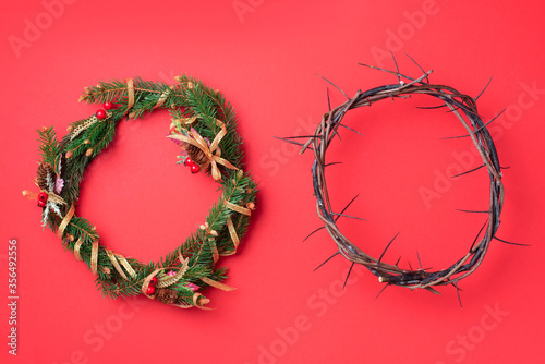 Christmas wreath and crown of thorns on red background. Remember the real Reason of the Season. Christian Christmas and Easter concept. Jesus Christ born to Die, born to Rise. Messiah, Emmanuel.
