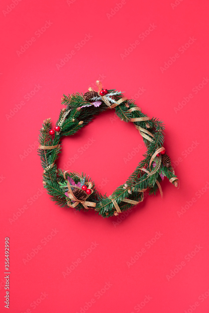 Handmade Christmas wreath on red background. Top view. Advent wreath. New year composition. Top view, flat lay. Copy space. Decoration for Christmas celebration. Greeting card, minimal concept