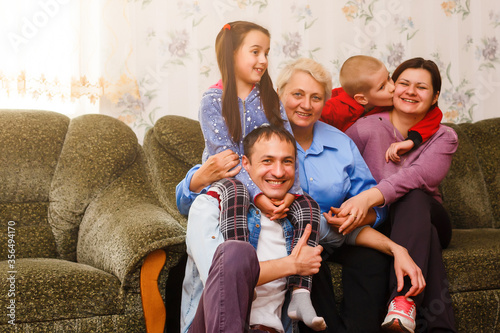 Grandmother and grandchildren sitting together on sofa in living room