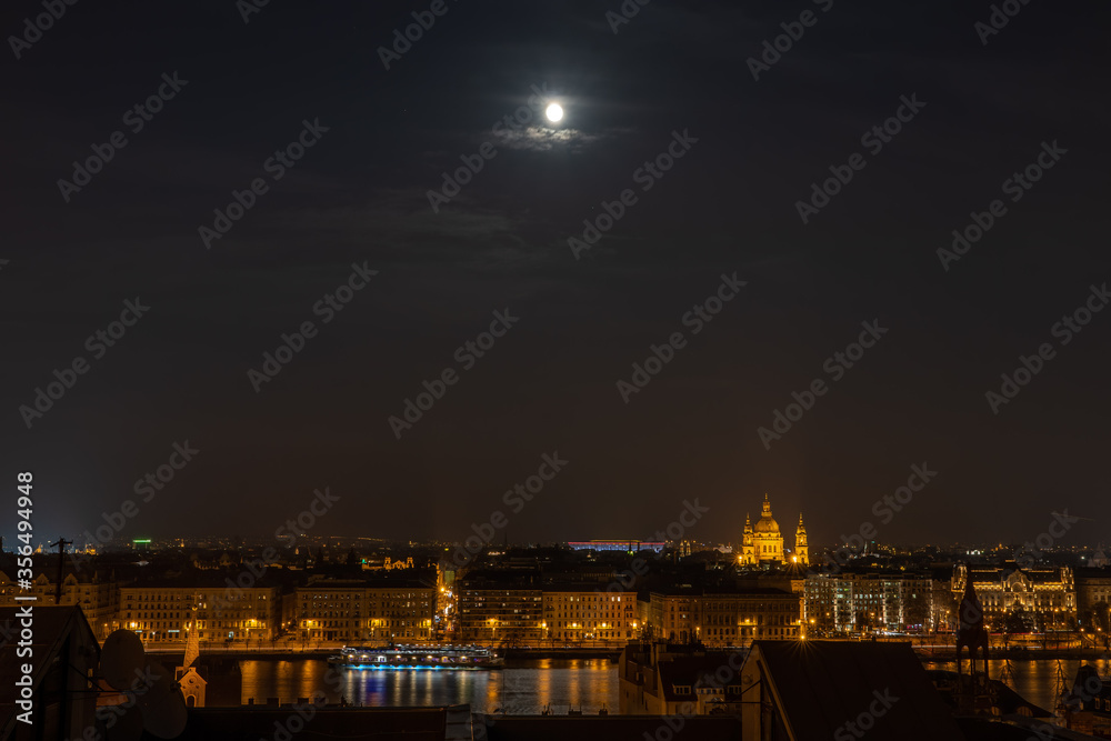 Danube river with lights on and full moon in Budapest winter