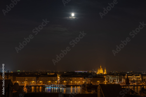 Danube river with lights on and full moon in Budapest winter