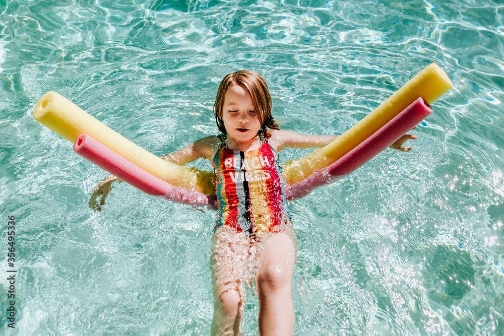 Tween Floating Inpool young girl floating on her back in pool with pool noodles Stock Photo ...