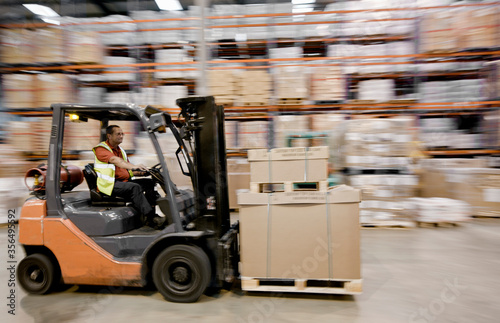 forklift truck speeding through warehouse photo