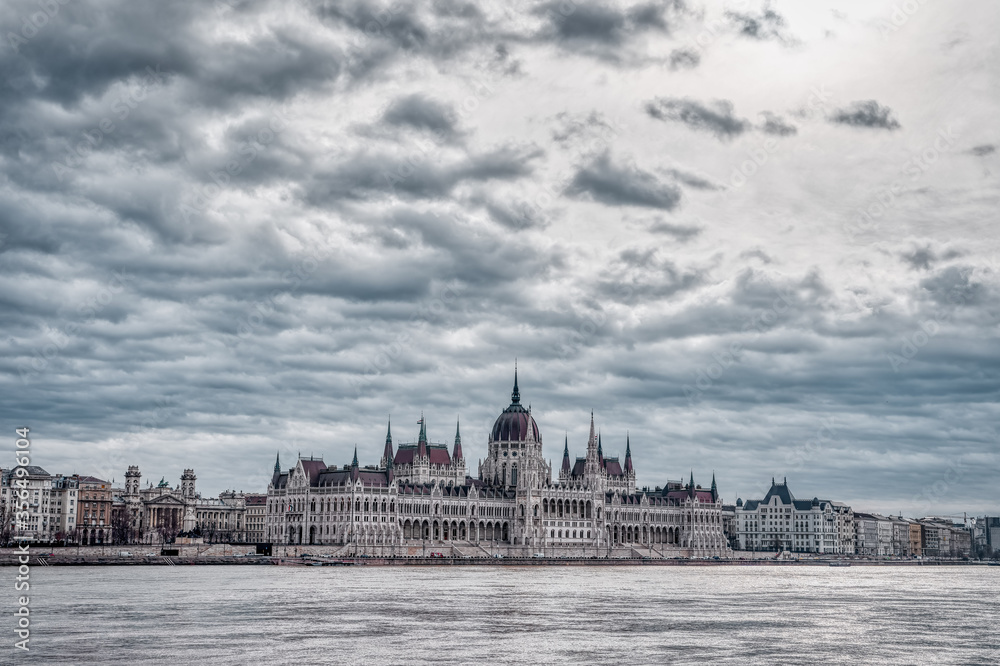 Hungarian Parliament facing Danube with clouds overhead in Budap
