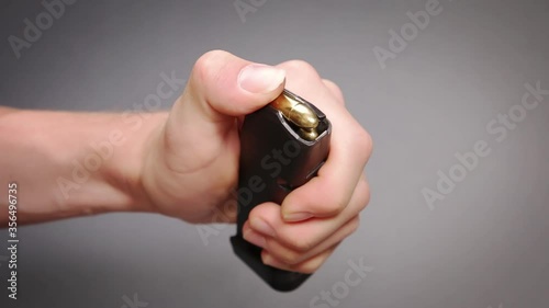 Man loading pistol cartridges into polymer magazine