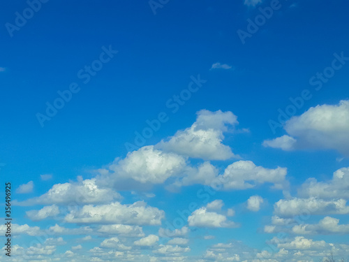 White fluffy clouds in the blue sky. Summer, cloudy. The air, the atmosphere.