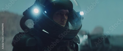 Caucasian female astronaunt checking hud on her suit while exploring planet surface, Mars colonization concept