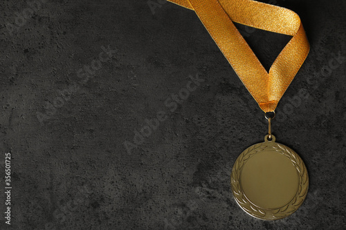 Gold medal on grey stone background, top view. Space for design photo