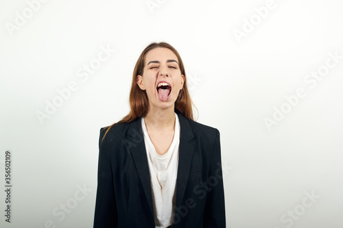 Fooling around outside, sticks out tongue as a sign of disobedience, protest and disrespect. Human emotions, reactions, feelings, attitude, having fun, grimacing healthy oral cavity. Attractive woman