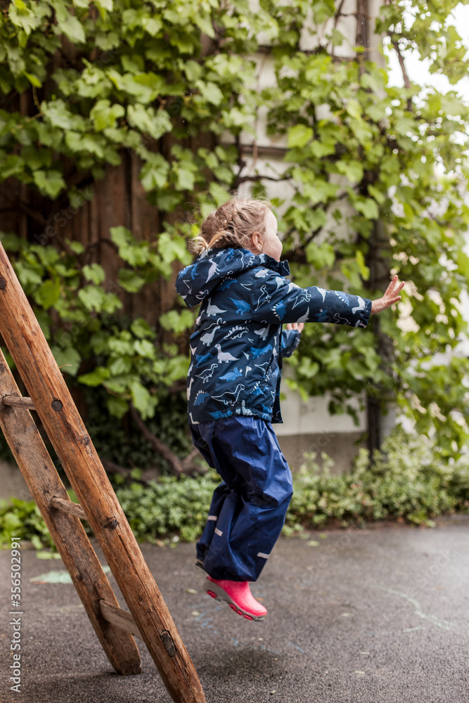 Child jumps from old step ladder. Small child bravely jumps from ladder. Kind springt von alter Trittleiter. Kleines Kind hüpft mutig von Leiter. Child jumps from old step ladder. Small child bravely jumps from ladder. Kind springt von alter Trittleiter. Kleines Kind hüpft mutig von Leiter.