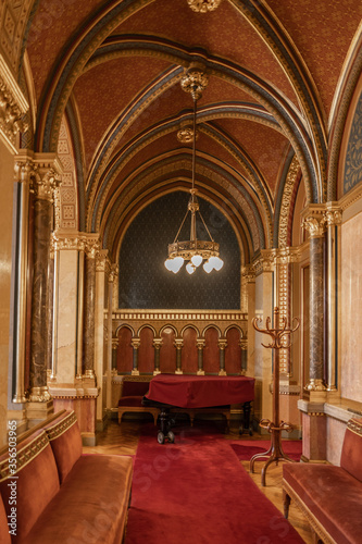 Rib vaults corridor with red carpet and gold ceiling lamp