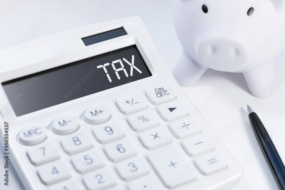 Word Tax on calculator. Business and tax concept on white background. Top view. Word Tax on calculator. Business and tax concept on white background. Top view.