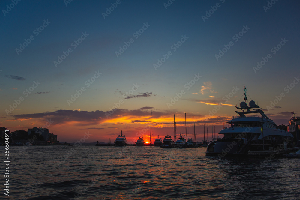 Boats during colorful sunset at the harbour in Zadar, Croatia