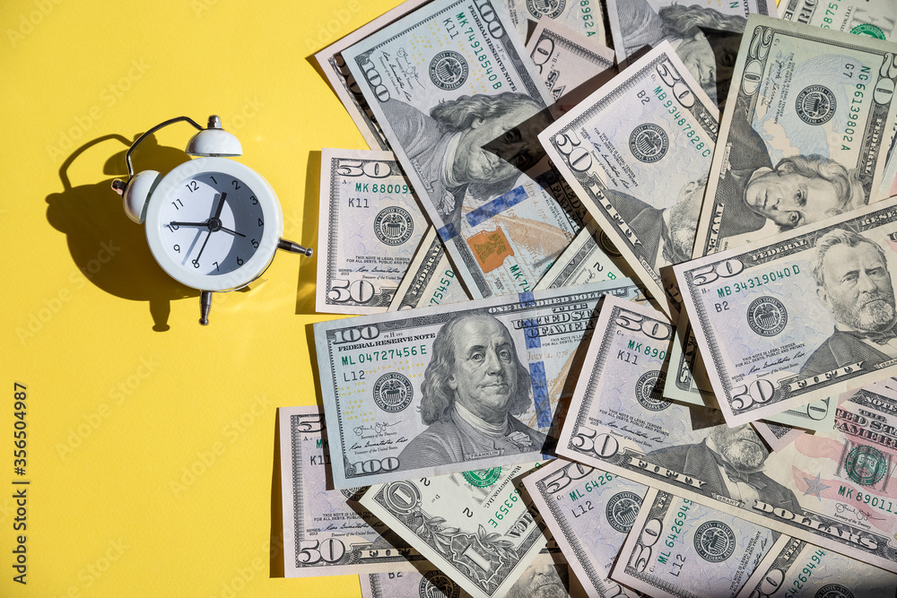 alarm clock and US Banknotes. Car loan, Financial, saving money, insurance and leasing time concepts.Time to pay up.time to pay your bills.money growing concept alarm clock and US Banknotes. Car loan, Financial, saving money, insurance and leasing time concepts.Time to pay up.time to pay your bills.money growing concept