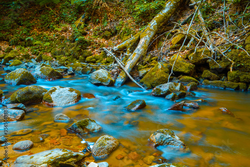 Long exposure picture of a stream flowing with rocks and natural light 