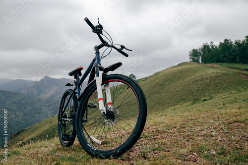 Fototapeta Naklejka Na Ścianę i Meble -  Синий велосипед на крутом горном склоне в горах.