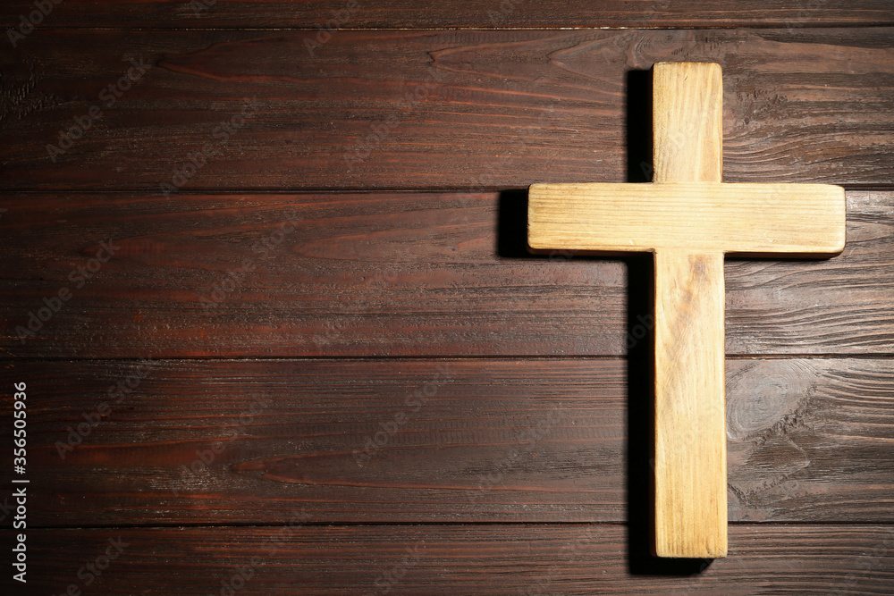 Christian cross on wooden background, top view with space for text. Religion concept