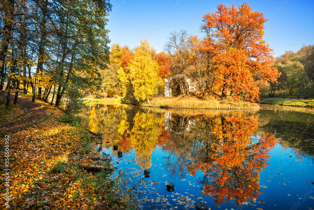 Big red oak and arch on the island with reflection in the pond in Tsaritsyno park in Moscow Big red oak and arch on the island with reflection in the pond in Tsaritsyno park in Moscow