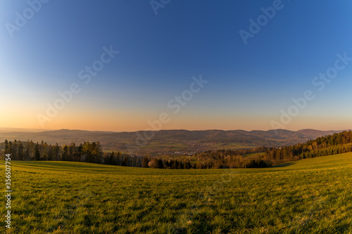 Sunset on a mountainous landscape with a village lying under the mountains Zasova Czech Republic.