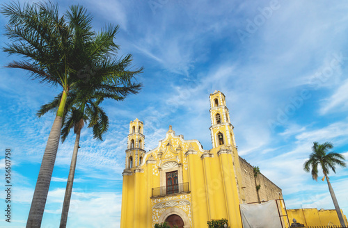 Colonial church 'SAN Juan Bautista' in the colonial center of Merida with palm trees, Yucatan, Mexico photo