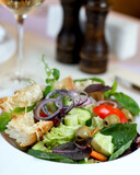 big tasty salad lies on white plate on isolate