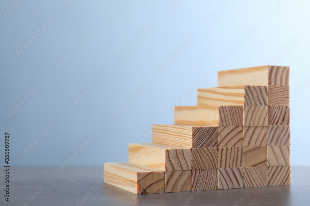Steps made with wooden blocks on grey table, space for text. Career ladder Steps made with wooden blocks on grey table, space for text. Career ladder