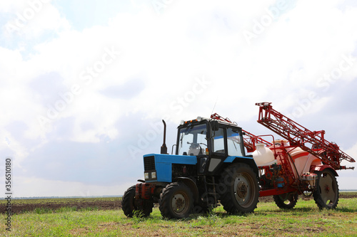 Modern agricultural equipment in field under cloudy sky