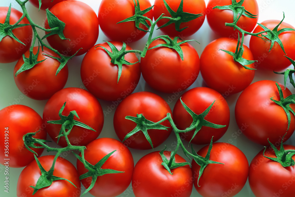 lots of red tomatoes on a branch as background