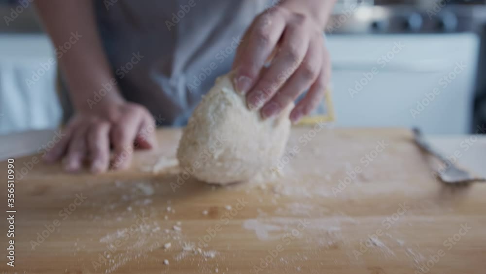 follow focus, Woman kneading fresh dough at home in her kitchen, slow motion. follow focus, Woman kneading fresh dough at home in her kitchen, slow motion.