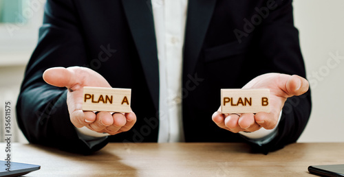Business concept, a man offers a choice of wooden cubes with the inscriptions plan a and plan b