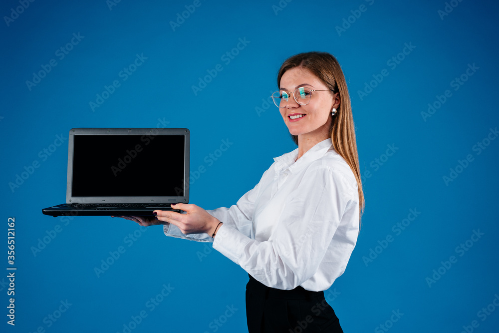 American business woman holding a laptop, isolated on blue background American business woman holding a laptop, isolated on blue background