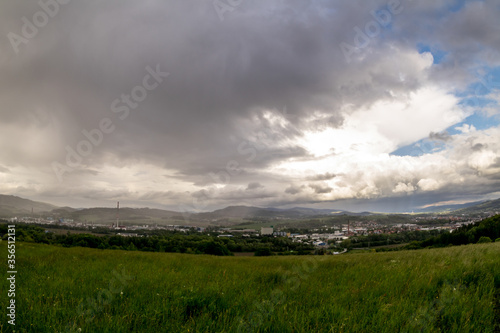 Landscape view of the town of Valasske Mezirici during the rain in the hills on the horizon where the sun shines into the landscape.