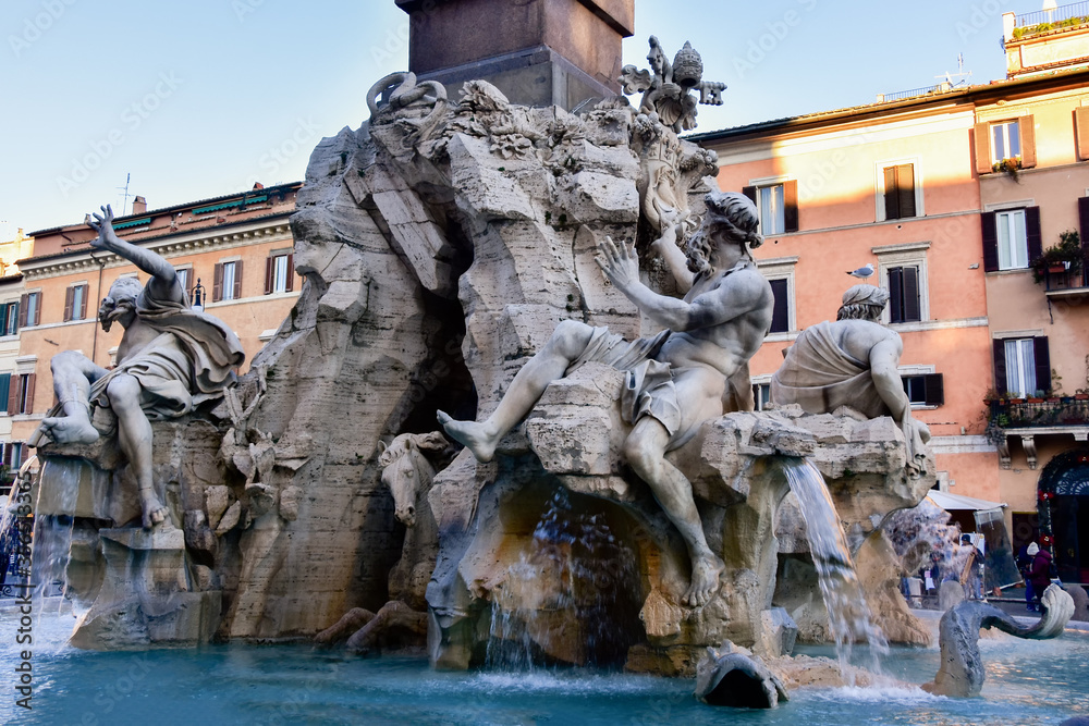 Fountain of the Four Rivers on Piazza Navona. Ancient fountain, statues, obelisk design of Bernini. Famous landmark touristic location near Sant Agnese in Agone church in Rome, Italy