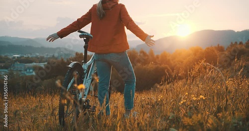 Woman in bicycle helmet with bike rides in country, Happy traveler girl biking in park on sunny summer day. Active healthy outdoor sport fun activity. Freedom, Travel, Journey.