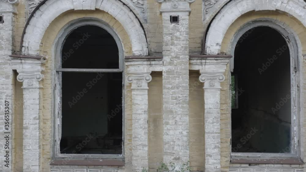 Broken arched windows of an abandoned old manor house (mansion house). Deserted 19th century building. Aerial side view. Close-up shot Broken arched windows of an abandoned old manor house (mansion house). Deserted 19th century building. Aerial side view. Close-up shot