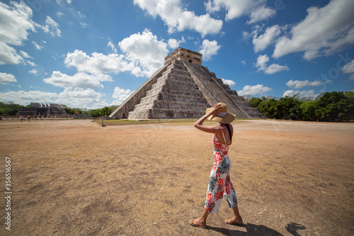Anonymous female traveler enjoying view of ancient building on sunny day in Mexico photo